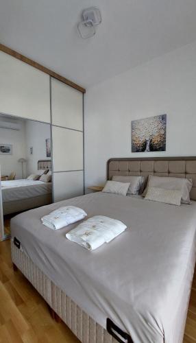 a large white bed with two pillows on it at D&M Lux2 in Podgorica