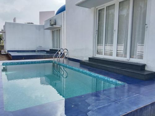 a swimming pool with blue water in a house at Greece In Blue in Kandivalli
