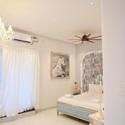a bedroom with a bed and a ceiling fan at Greece In Blue in Kandivalli
