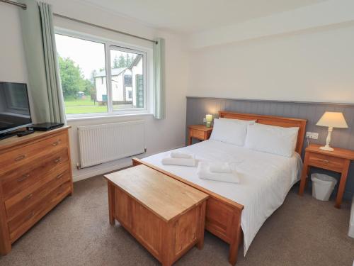 a bedroom with a large bed and a television at Whitbarrow 24 in Penrith
