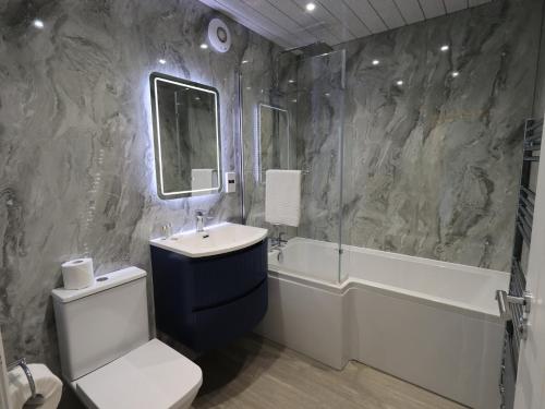 a bathroom with a sink and a toilet and a bath tub at Whitbarrow 24 in Penrith