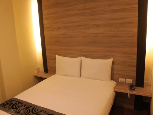 a bedroom with a bed with a wooden headboard at Shan Shui Hostel in Hualien City