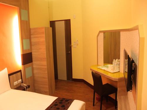 a hotel room with a bed and a desk with a mirror at Shan Shui Hostel in Hualien City