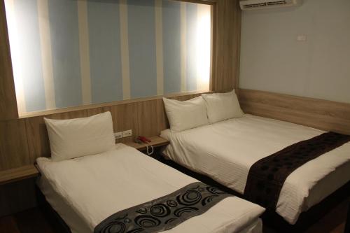 two beds in a small room with at Shan Shui Hostel in Hualien City