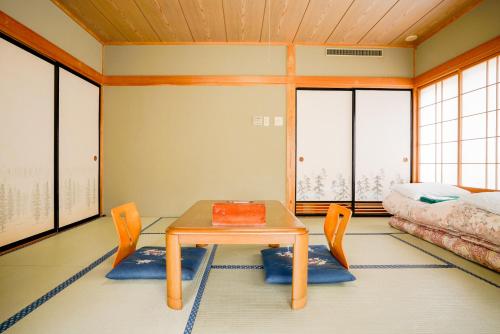 a room with a table and a bed at Shibuonsen YAMAICHIYA in Yamanouchi