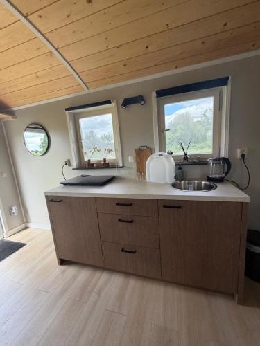 a kitchen with a sink and two windows at Shepherd Hutten Hunsel in Hunsel
