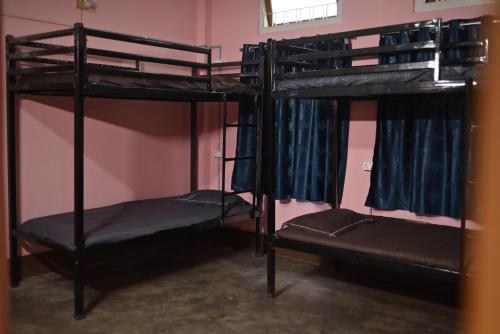 a room with three bunk beds in it at The Backpackers Hostel in Guwahati