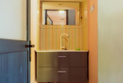 a bathroom with a sink and a mirror at Marionel Hôtel in Ampilahoa