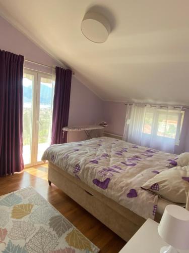 a bedroom with a bed and a large window at Purple Haze Apartments in Tivat