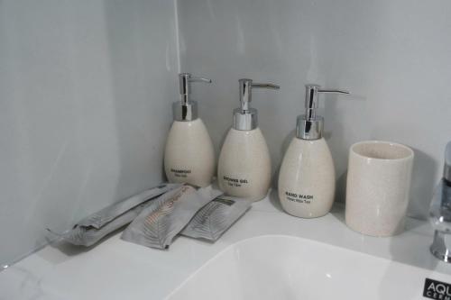 a group of four soap dispensers sitting on a counter at Reka Homestay in Thôn Dương Phẩm