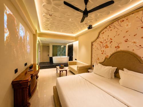 a bedroom with a bed and a bathroom with a tub at Hotel Nova Bloom in Ahmedabad