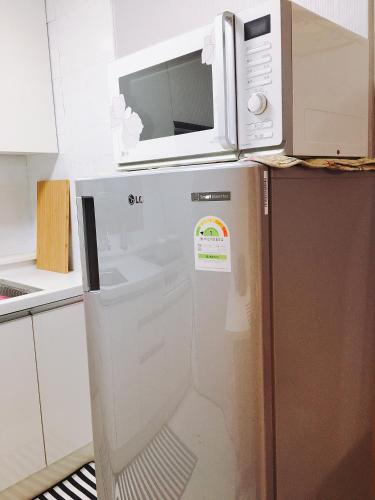 a microwave on top of a refrigerator in a kitchen at Riahouse KINTEX 1min 2room in Goyang