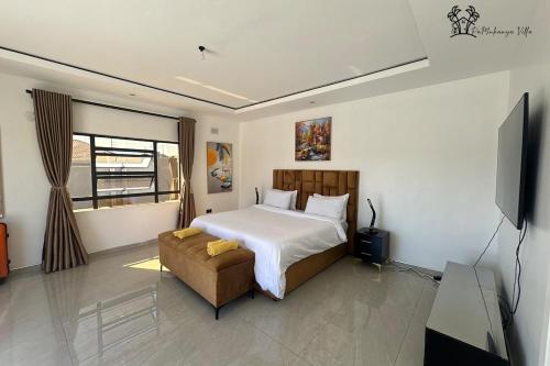 a bedroom with a bed and a couch and a television at Holiday Villa Marondera in Marondera
