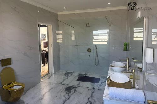 a white bathroom with a toilet and a shower at Holiday Villa Marondera in Marondera