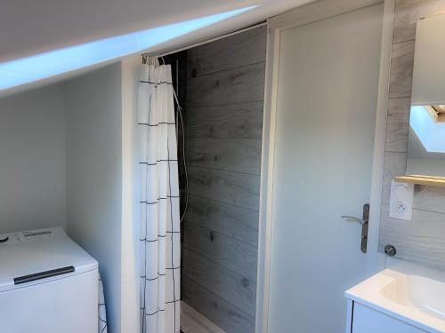 a bathroom with a wooden closet with a shower curtain at Appartement Cosy avec parking à proximité de la Gare et de toutes les commodités in Orléans