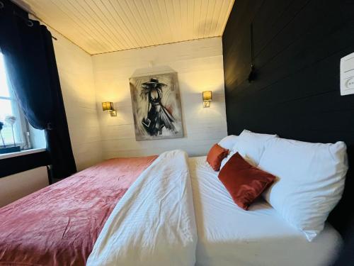 a bedroom with a bed with white sheets and pillows at Le cocoon de Nanou in Anloy