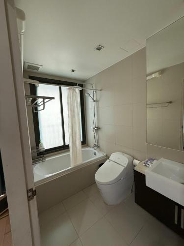 a bathroom with a toilet and a tub and a sink at ELiTE 61 THONGLOR in Sathani Khlong Tan