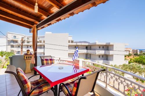 a balcony with a red table and chairs on it at Spacious 2BR Apartment with Balconies in Karpathos