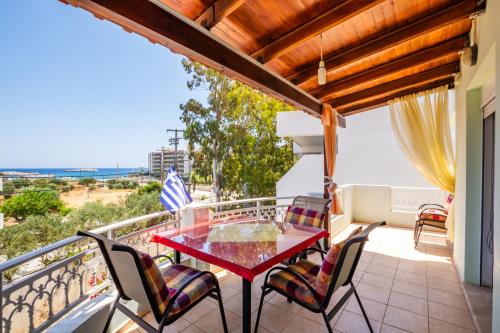 a balcony with a red table and chairs at Spacious 2BR Apartment with Balconies in Karpathos