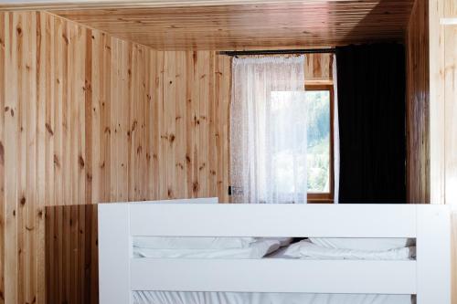 a white bed in a wooden room with a window at Melody Hotel in Bukovel