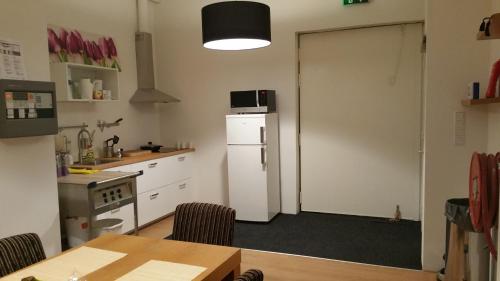 a kitchen with a refrigerator and a table with chairs at Whole building for yourself in Amsterdam