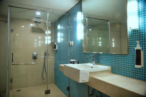 a bathroom with a sink and a shower at Peerless Hotel Hyderabad in Hyderabad