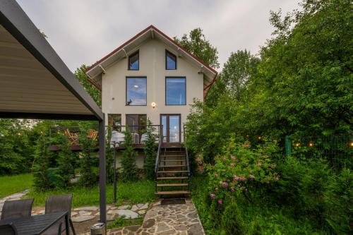 a house with a staircase leading up to it at Forest House Premium Breaza in Breaza de Sus