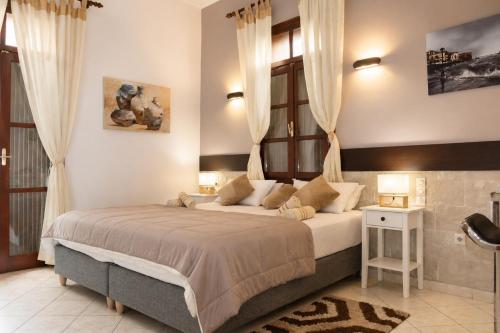 a bedroom with a large bed and a window at Enetiko Rooms in Chania