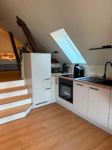 a kitchen with white cabinets and a skylight at Loft Günni mit Whirlpool in Wietzendorf