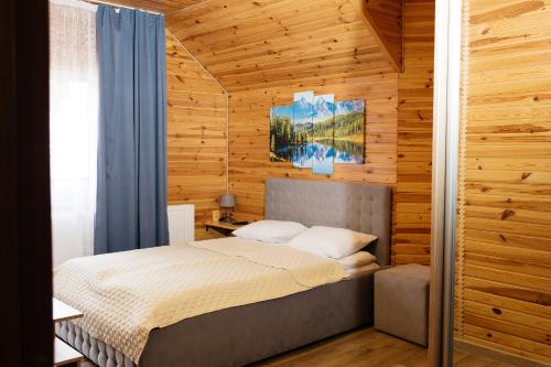a bedroom with a bed in a wooden wall at Melody Hotel in Bukovel