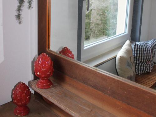 a mirror and some red vases on a wooden bench at Pension Glücklich in Horgenzell