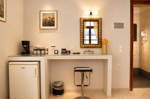 a bathroom with a counter with a stool and a mirror at Enetiko Rooms in Chania