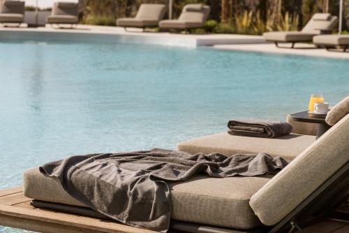a bed sitting next to a swimming pool at NĒRO Boutique Hotel in Imerovigli