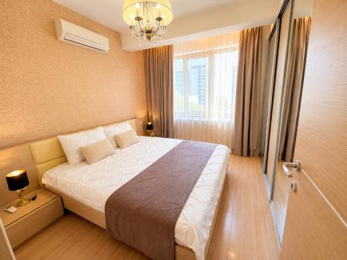 a hotel room with a bed and a window at HERASTRAU APARTMENTS 3 camere self check-in in Bucharest