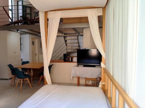 a bedroom with a bed and a tv and a table at Loft House Syros in Ermoupoli