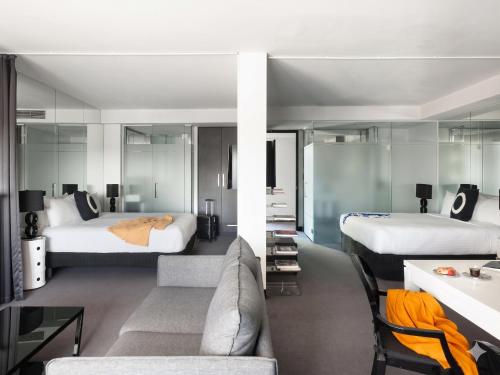 a hotel room with two beds and a couch at Elli Prahran in Melbourne