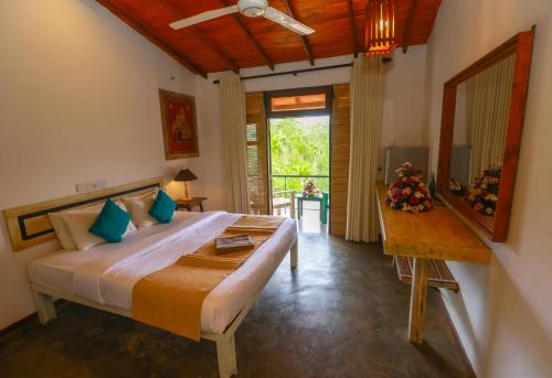 a bedroom with a bed and a table and a mirror at Amber Reach Cottages in Ella
