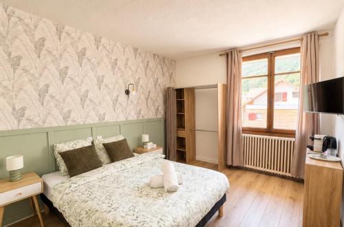 a bedroom with a bed and a television in it at Le Lac Bleu - Sevrier in Sévrier