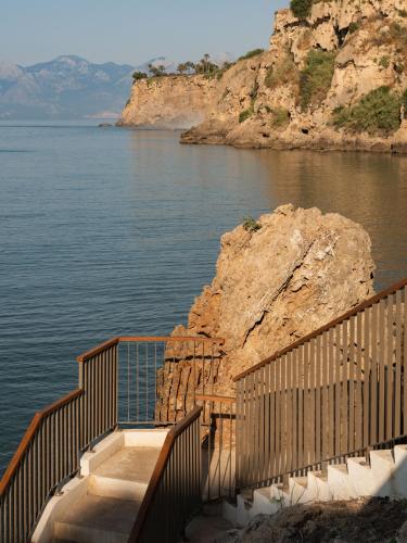 a staircase leading down to a body of water at Keyla Hotel & Beach - Adult Only in Antalya