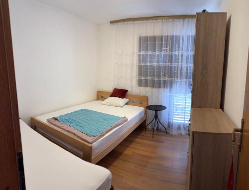 a small bedroom with a bed and a window at Guest House Oleander in Petrovac na Moru