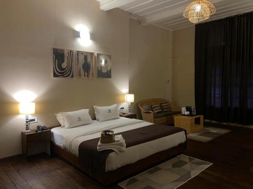 ein Schlafzimmer mit einem großen Bett und einem Stuhl in der Unterkunft Colonial 44 in Kohīma