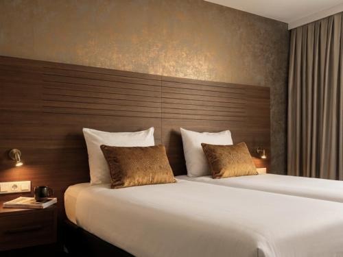 two beds in a hotel room with two beds sidx sidx sidx at A-Hotel Oosterhout in Oosterhout