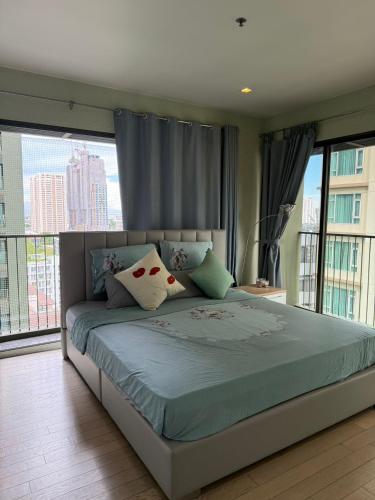 a bedroom with a bed with a large window at ELiTE 61 THONGLOR in Sathani Khlong Tan