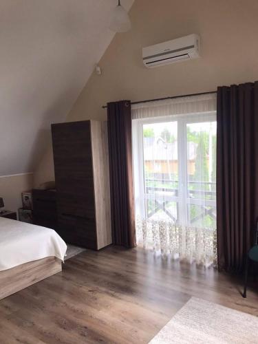 a bedroom with a bed and a large window at Lake House in Svityazʼ