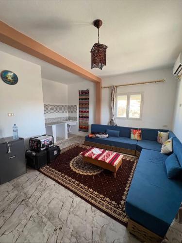 a living room with a blue couch and a rug at dar fatma matmata in Matmata