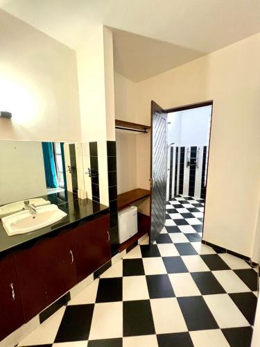 a bathroom with a sink and a checkered floor at Hotel One Sixty in Dehiwala