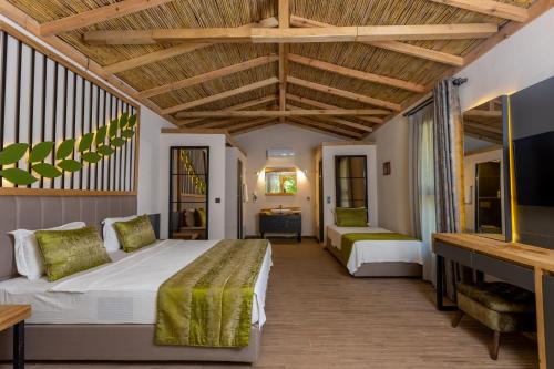 a bedroom with two beds and a tv at Gizli Cennet Villages Hotel in Fethiye