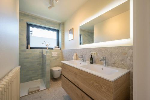 a bathroom with a sink and a toilet and a mirror at Zenzalea Oostkamp in Oostkamp
