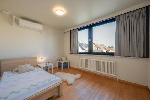 a bedroom with a bed and a large window at Zenzalea Oostkamp in Oostkamp
