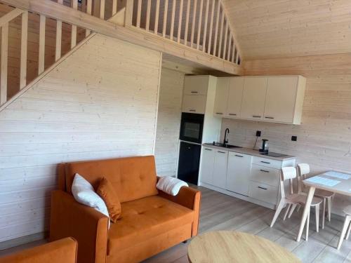 a living room with a couch and a kitchen at PAKLADA Domek całoroczny 2 in Bak